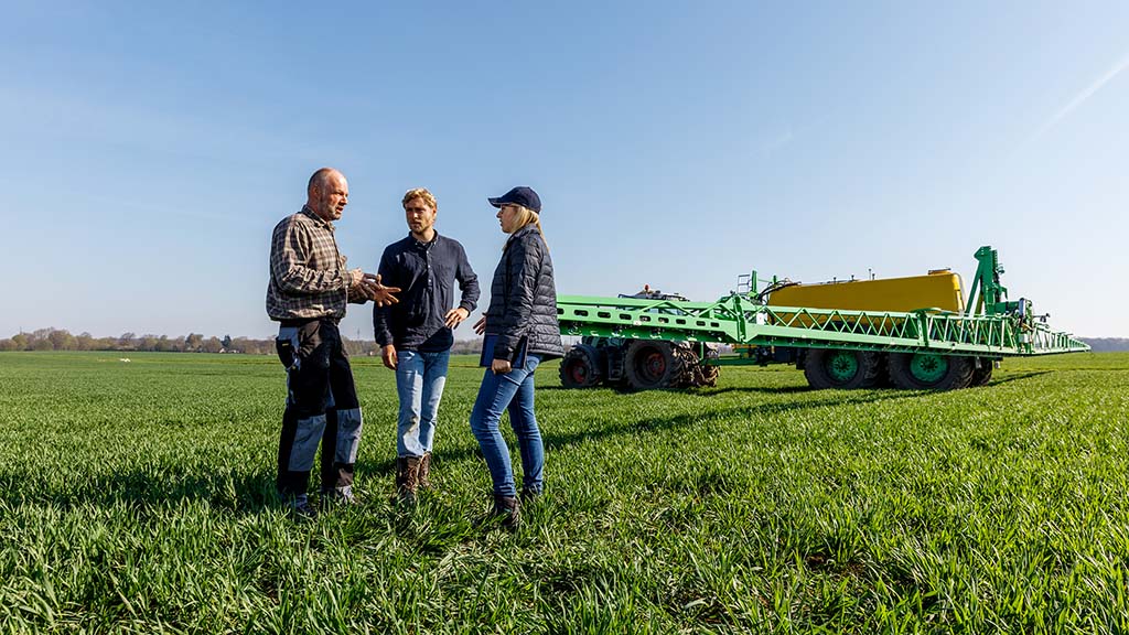 Landwirte diskutieren vor Feldspritze